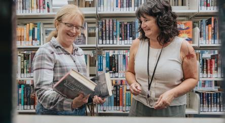 A staff member helps a customer find a book at Maple Ridge Public Library.